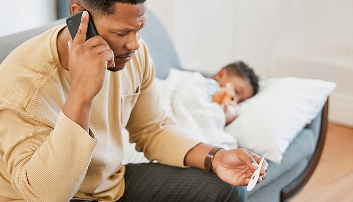 A father calls the doctor for his sick son